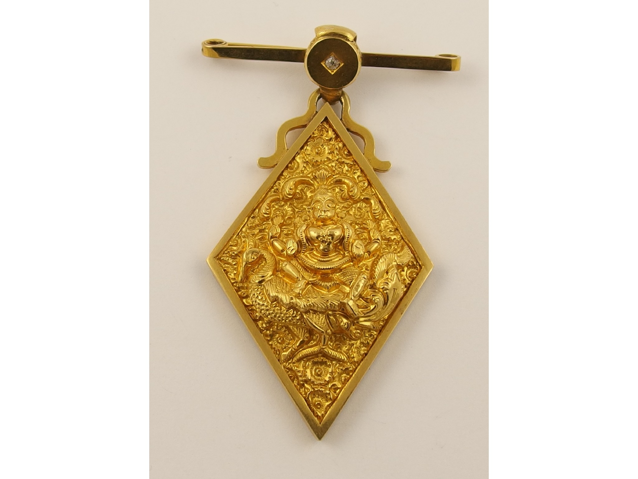 Appraisal: An Anglo Indian broochin bright yellow metal featuring a repousse