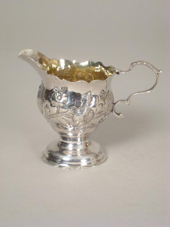 Appraisal: A George III Cream Jug floral embossed on pedestal base