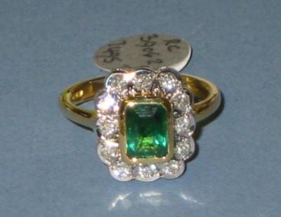 Appraisal: AN EMERALD AND DIAMOND CLUSTER RING the trapp-cut emerald collet