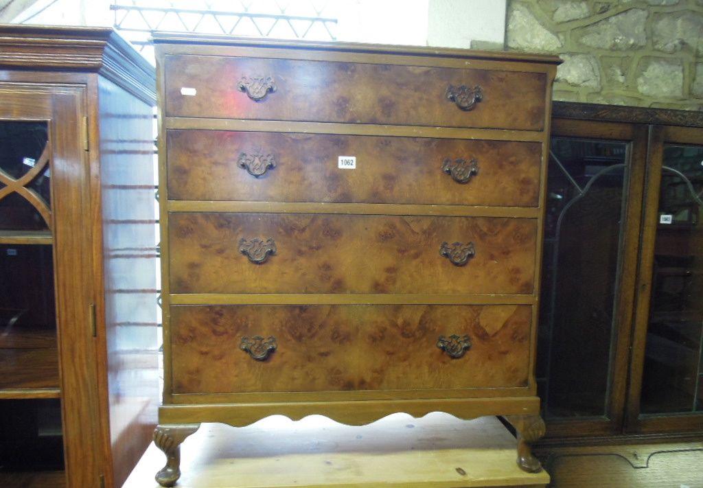 Appraisal: A walnut veneered bedroom chest fitted with four long graduated