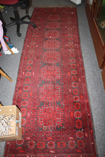 Appraisal: A PAKISTAN RED GROUND RUNNER with central medallions within a