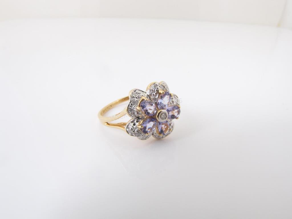 Appraisal: A K yellow gold flower ring with tanzanite and accent