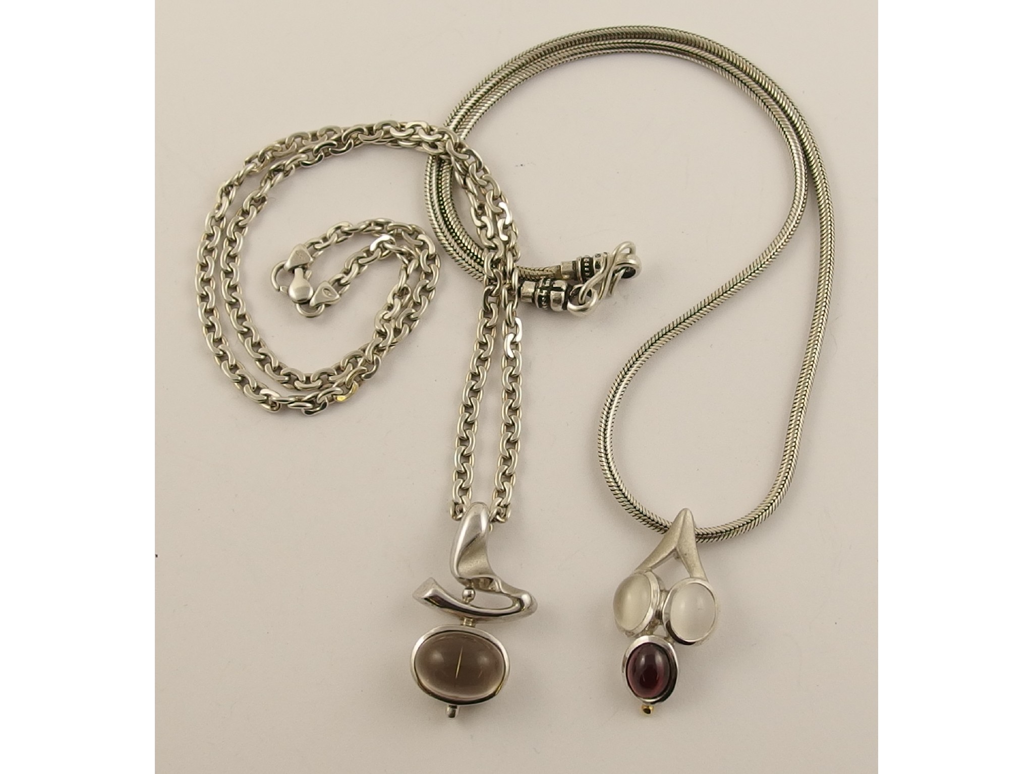 Appraisal: Two silver retro style gem set pendants featuring garnet moonstone