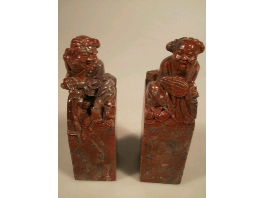 Appraisal: A pair of Chinese rouge soapstone seal figures on square