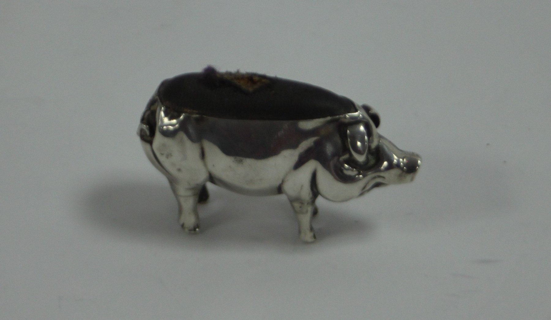 Appraisal: A novelty silver pin cushion of pig form marks rubbed