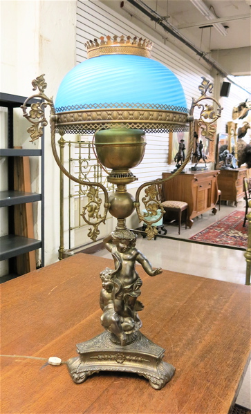 Appraisal: VICTORIAN CHERUB PARLOR LAMP having blue satin glass shade supported