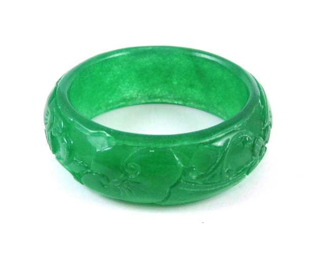 Appraisal: CHINESE CARVED GREEN JADE BANGLE The round translucent green jade