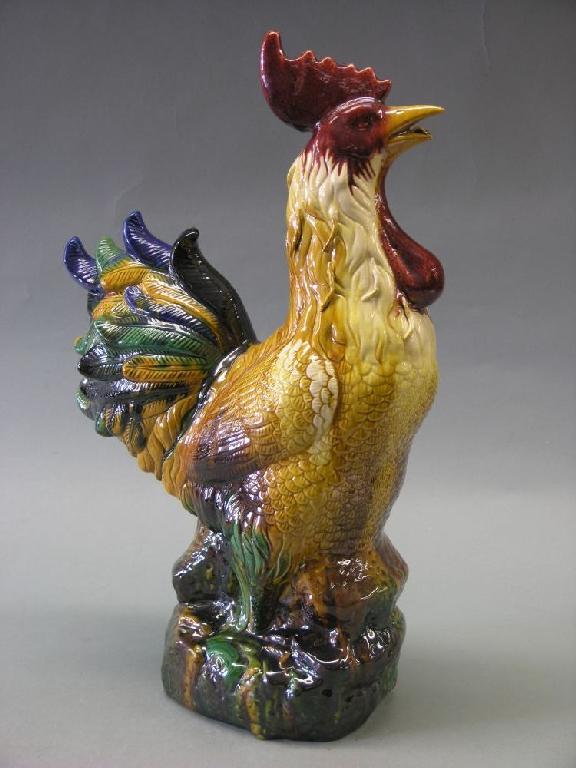 Appraisal: An earthenware cockerel model glazed in green blue and ochre