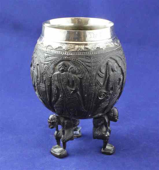 Appraisal: An Edwardian silver mounted coconut cup carved with panels of