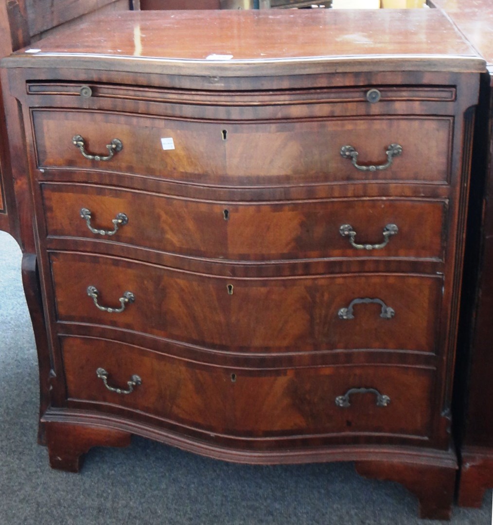 Appraisal: A th century mahogany serpentine chest the brushing slide over