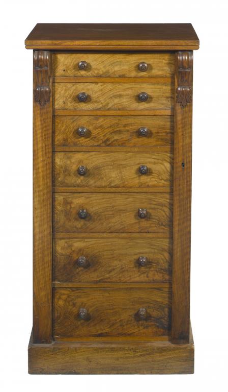 Appraisal: A VICTORIAN WALNUT WELLINGTON CHEST fitted seven graduated drawers flanked