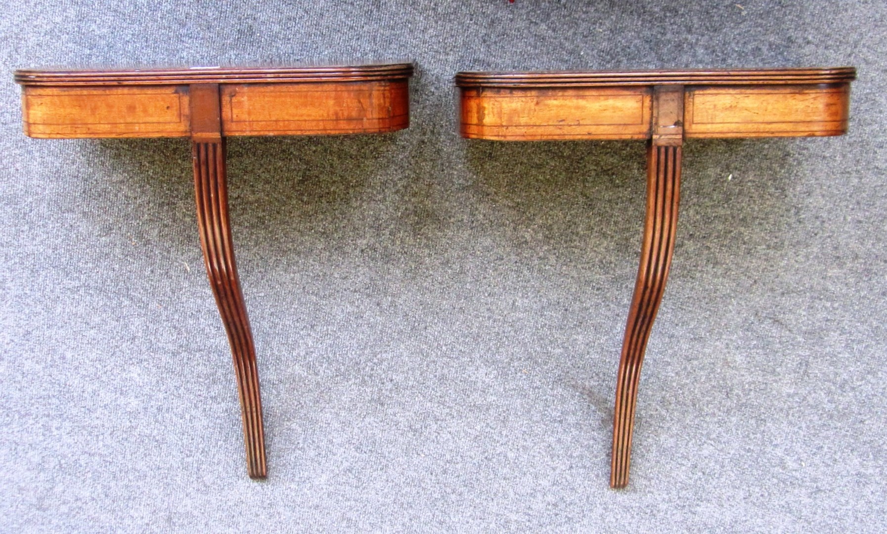 Appraisal: A pair of inlaid mahogany rounded rectangular console tables with