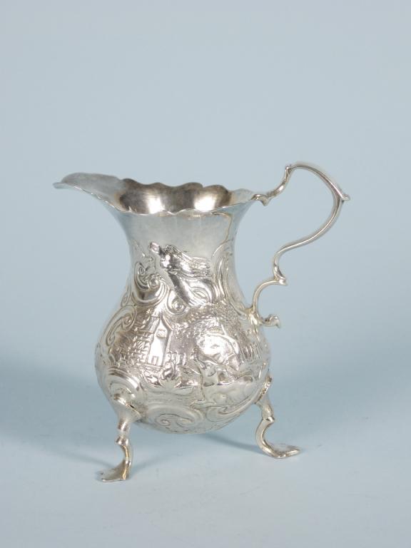 Appraisal: A Georgian baluster Cream Jug embossed animals and birds in