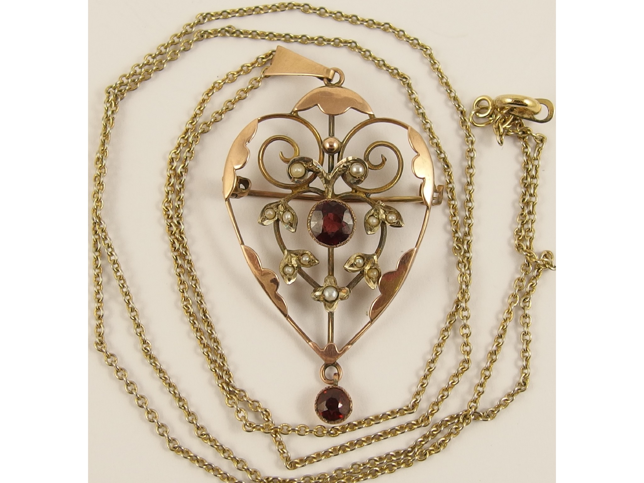 Appraisal: A garnet and pearl set Edwardian pendant brooch and chain