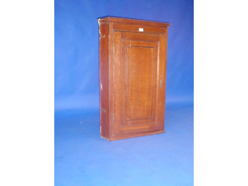 Appraisal: A Georgian oak hanging corner cupboard with single panel door