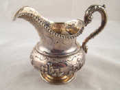 Appraisal: A silver cream jug with leaf capped handle gadrooned rim