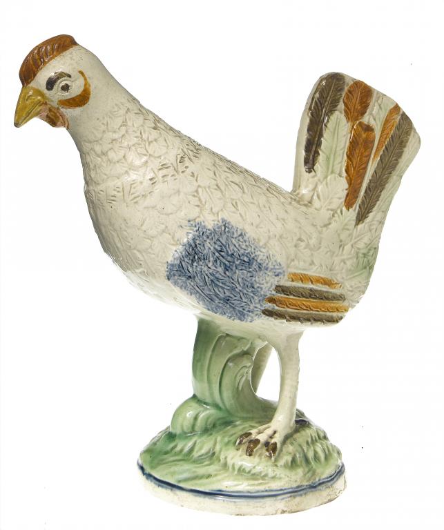 Appraisal: A CREAMWARE MODEL OF A COCKEREL on a leafy green