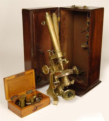 Appraisal: A brass binocular microscope with rack and pinion focusing with