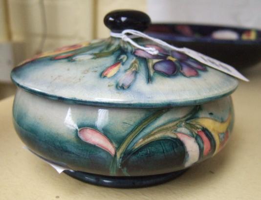 Appraisal: A Moorcroft lidded powder pot decorated with spring flowers against