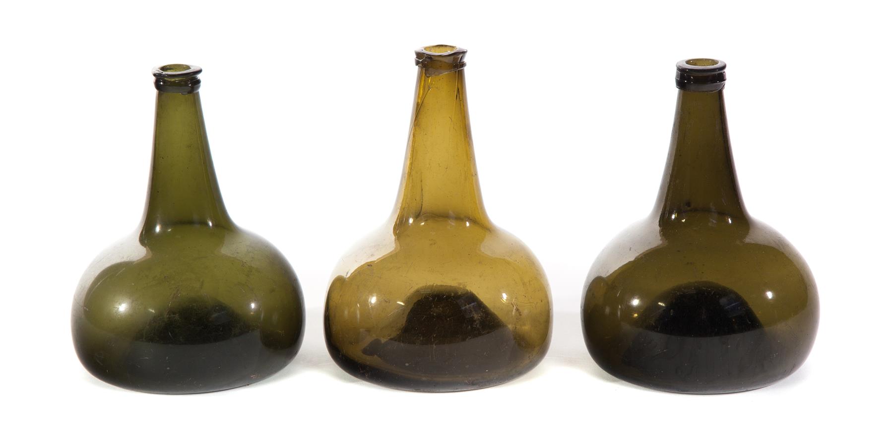 Appraisal: THREE BLOWN GLASS ONION BOTTLES European th century Olive green