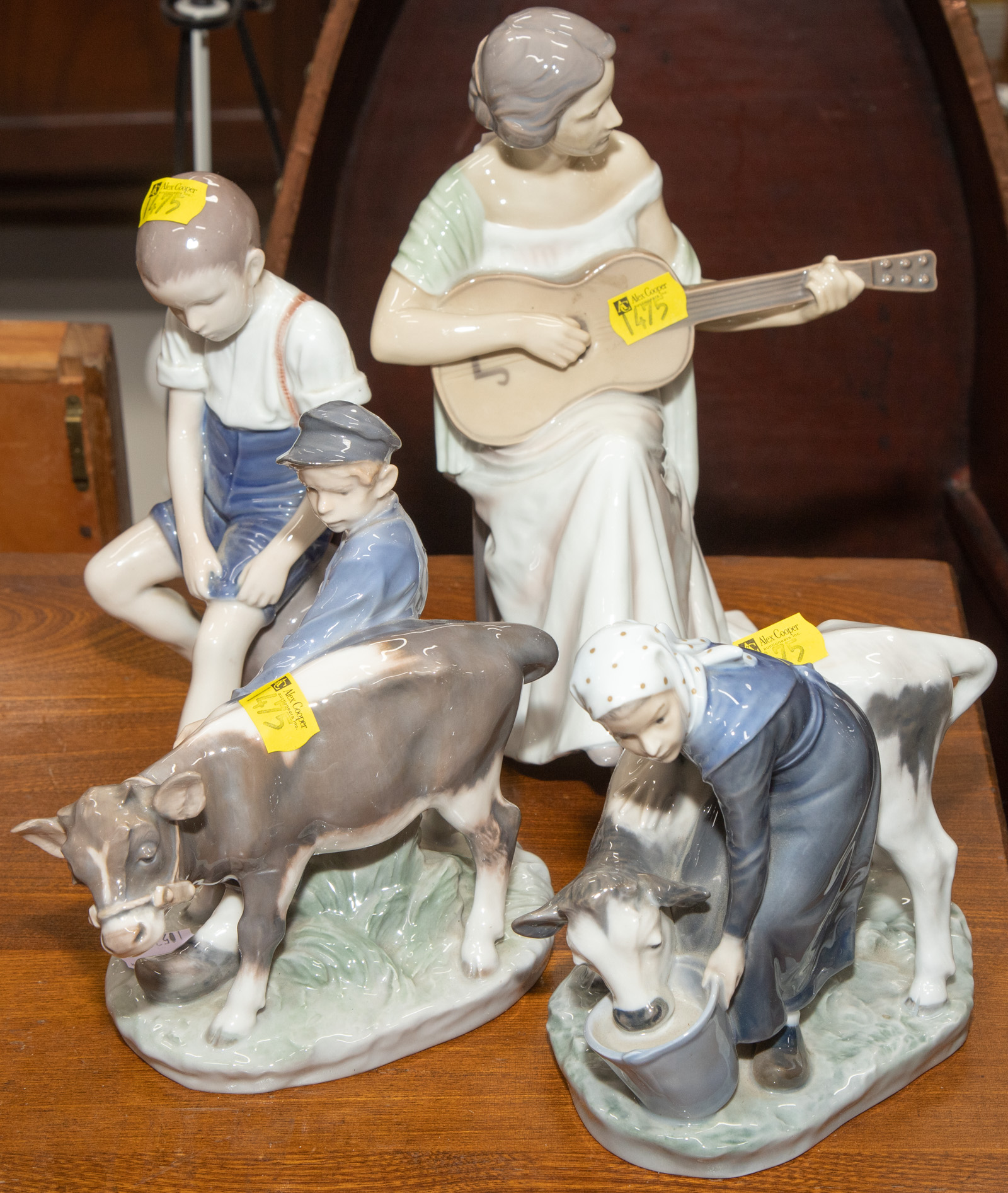 Appraisal: FOUR PAINTED PORCELAIN FIGURES Including a Royal Copenhagen cowherd and