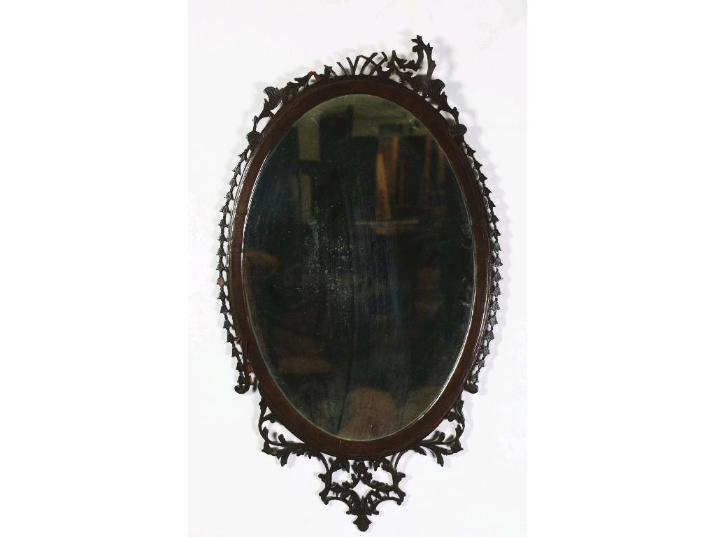 Appraisal: ANTIQUE CARVED MAHOGANY WALL MIRROR the oval plate in a