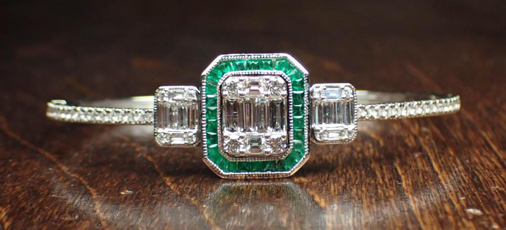 Appraisal: DIAMOND EMERALD AND EIGHTEEN KARAT GOLD BANGLE The oval hinged