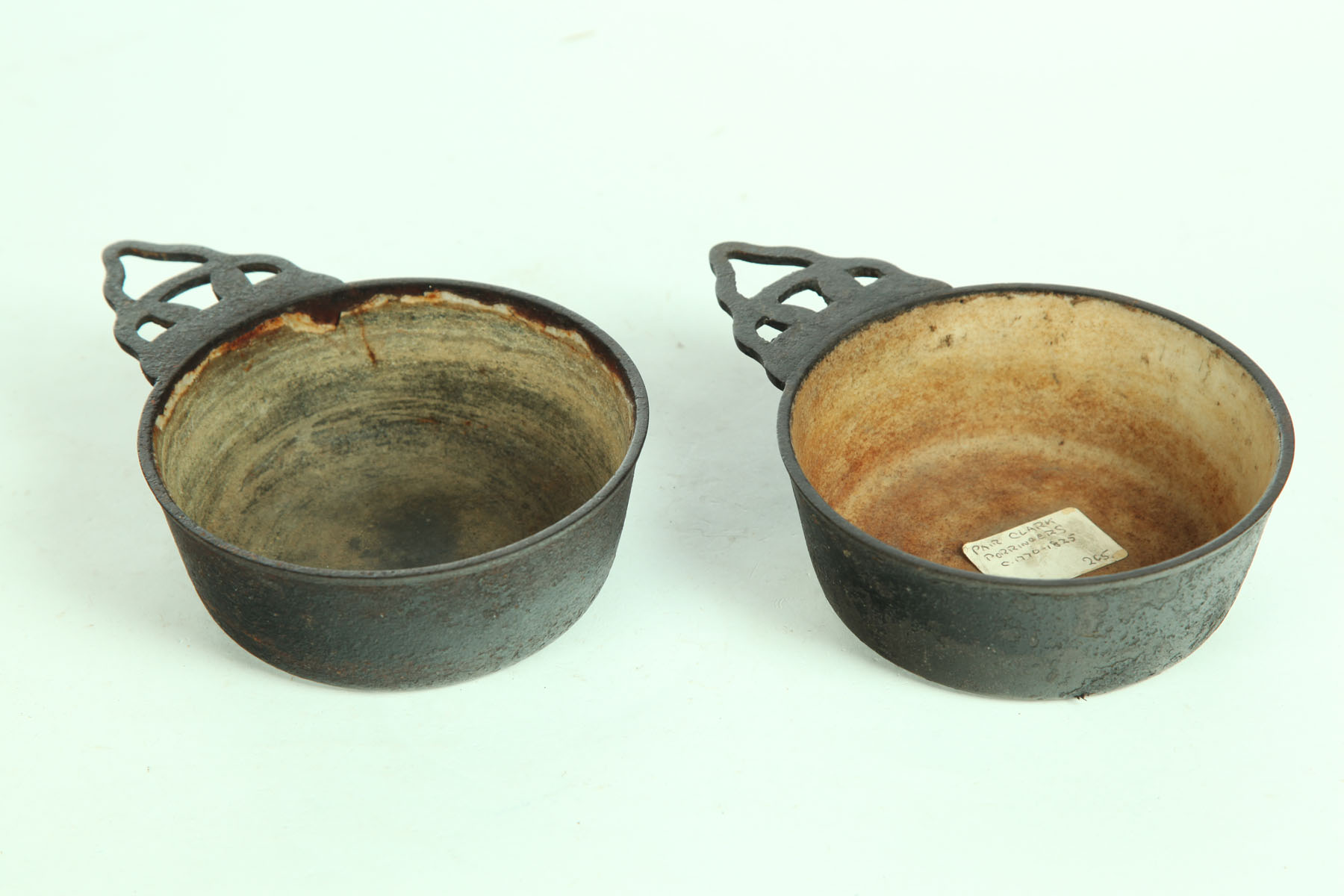 Appraisal: TWO CAST IRON PORRINGERS American th century Both marked ''Clark's