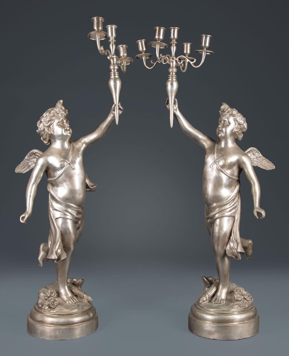 Appraisal: Pair of Continental Silvered Metal Figural Candelabra winged cherub standard