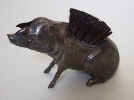 Appraisal: A silver pen wipe modelled as a seated pig with