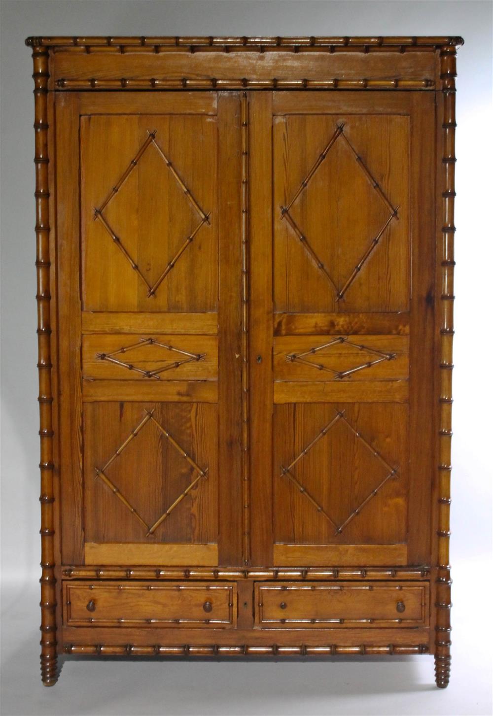 Appraisal: FAUX BAMBOO ARMOIRE the faux bamboo decorated pediment above double