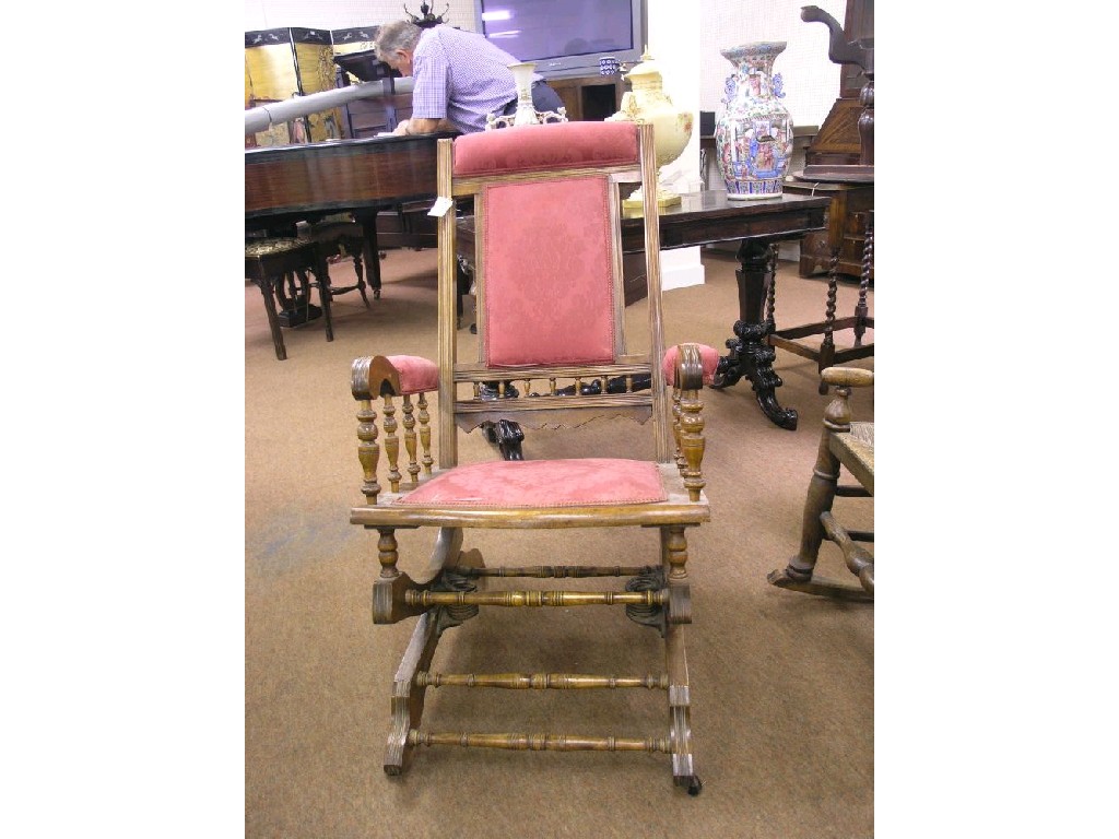 Appraisal: A late Victorian walnut framed rocking armchair with turned spindle