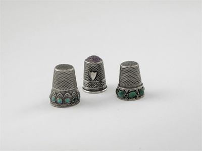 Appraisal: Three thimbles one set with an amethyst coloured glass dome