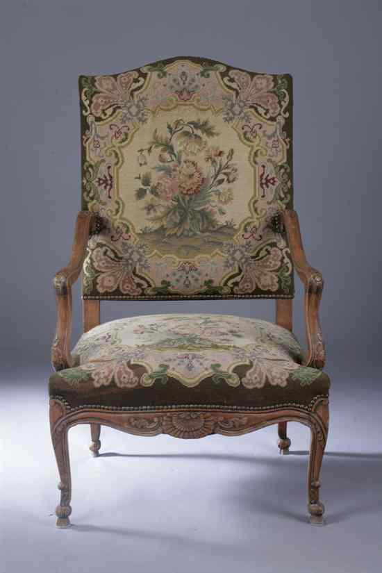 Appraisal: CONTINENTAL STYLE CARVED OAK OPEN-ARM CHAIR Needlepoint upholstery Arched crest