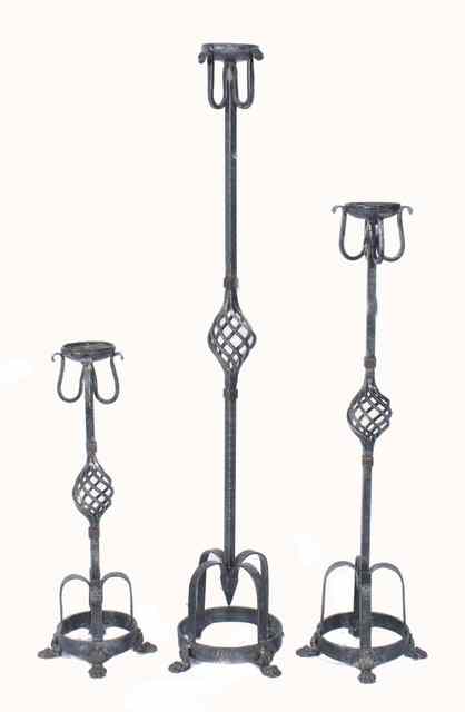 Appraisal: A GRADUATED SET OF THREE WROUGHT IRON CANDLE STANDS the