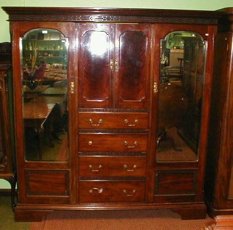 Appraisal: An Edwardian mahogany wardrobe compactum with blind fret dentil moulded