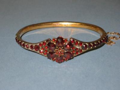 Appraisal: A VICTORIAN GARNET BANGLE with central flower head on a