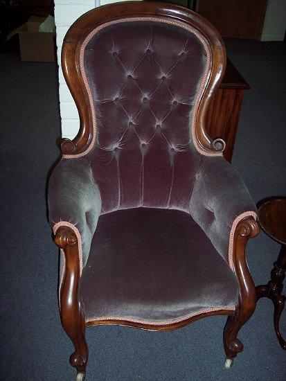 Appraisal: A Victorian walnut framed fireside chair the button back above