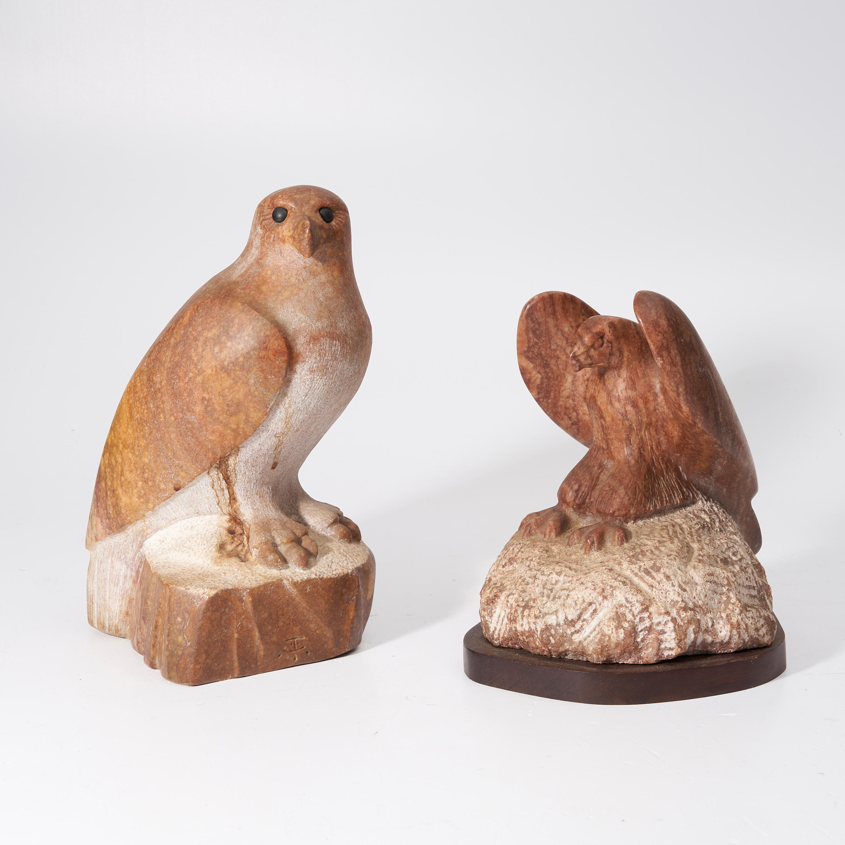 Appraisal: TWO CONTEMPORARY CARVED STONE BIRDS OF PREY one on a