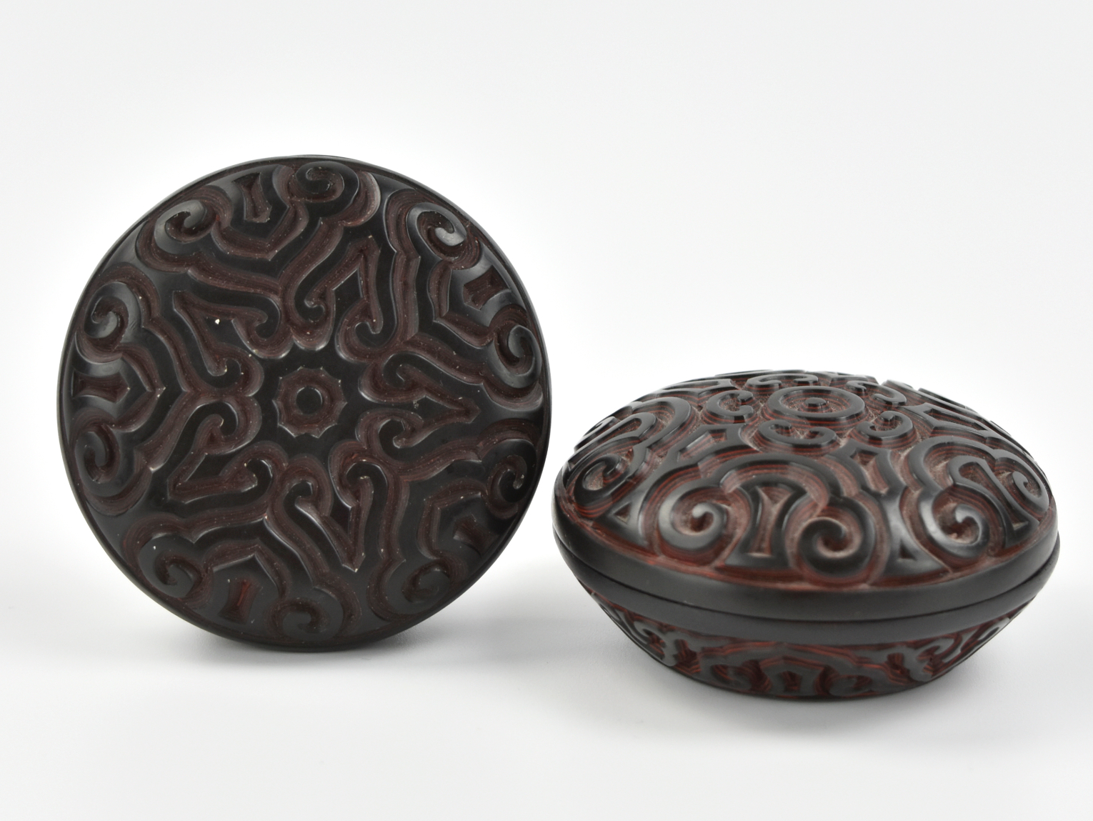 Appraisal: rounded black lacquer wood boxes with scrolls carved in low