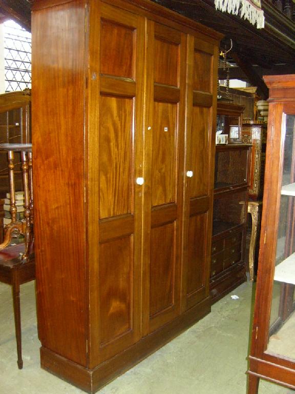 Appraisal: A large mahogany side cupboard enclosed by three panelled doors