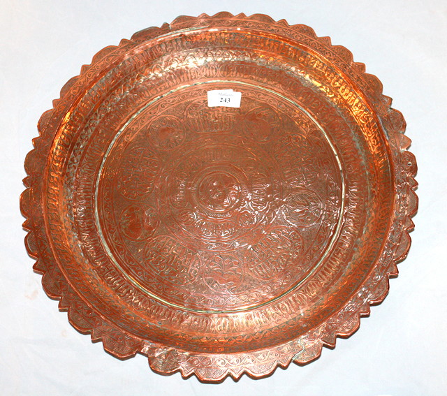 Appraisal: AN ISLAMIC ENGRAVED COPPER DISH with shaped edge and stylised