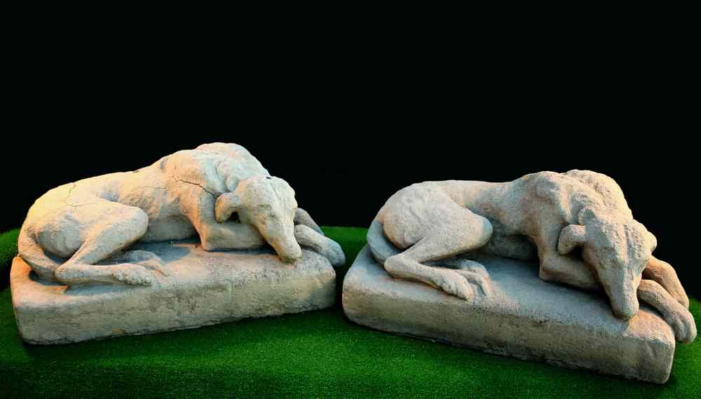 Appraisal: CAST SANDSTONE GARDEN FIGURES - Pair of recumbent dogs lying