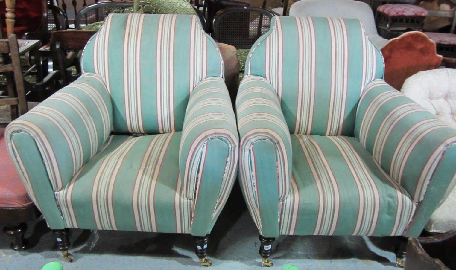 Appraisal: A pair of easy armchairs on turned mahogany supports