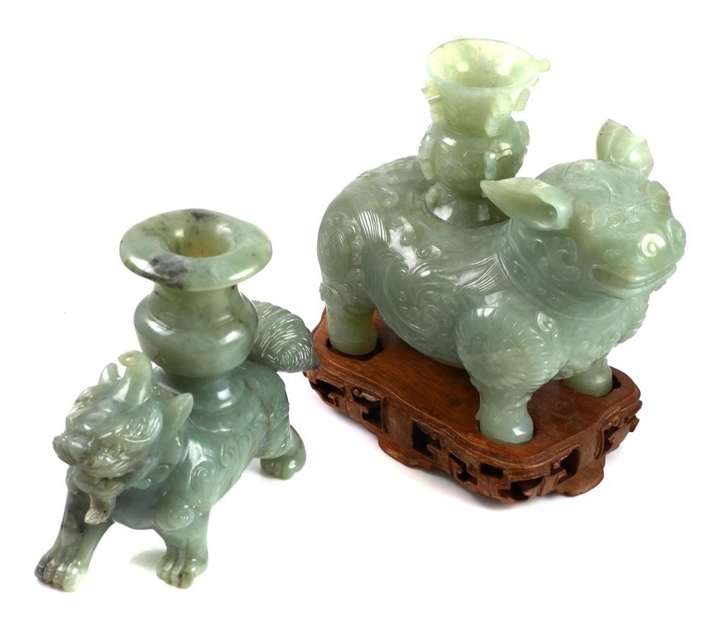 Appraisal: Two carved jade guardian lions each with a vessel on