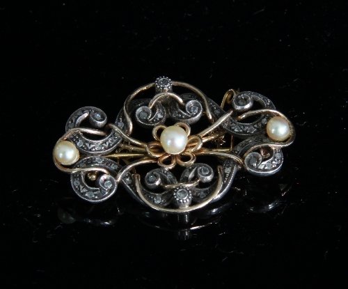 Appraisal: A diamond and pearl brooch of scrolling openwork form centred