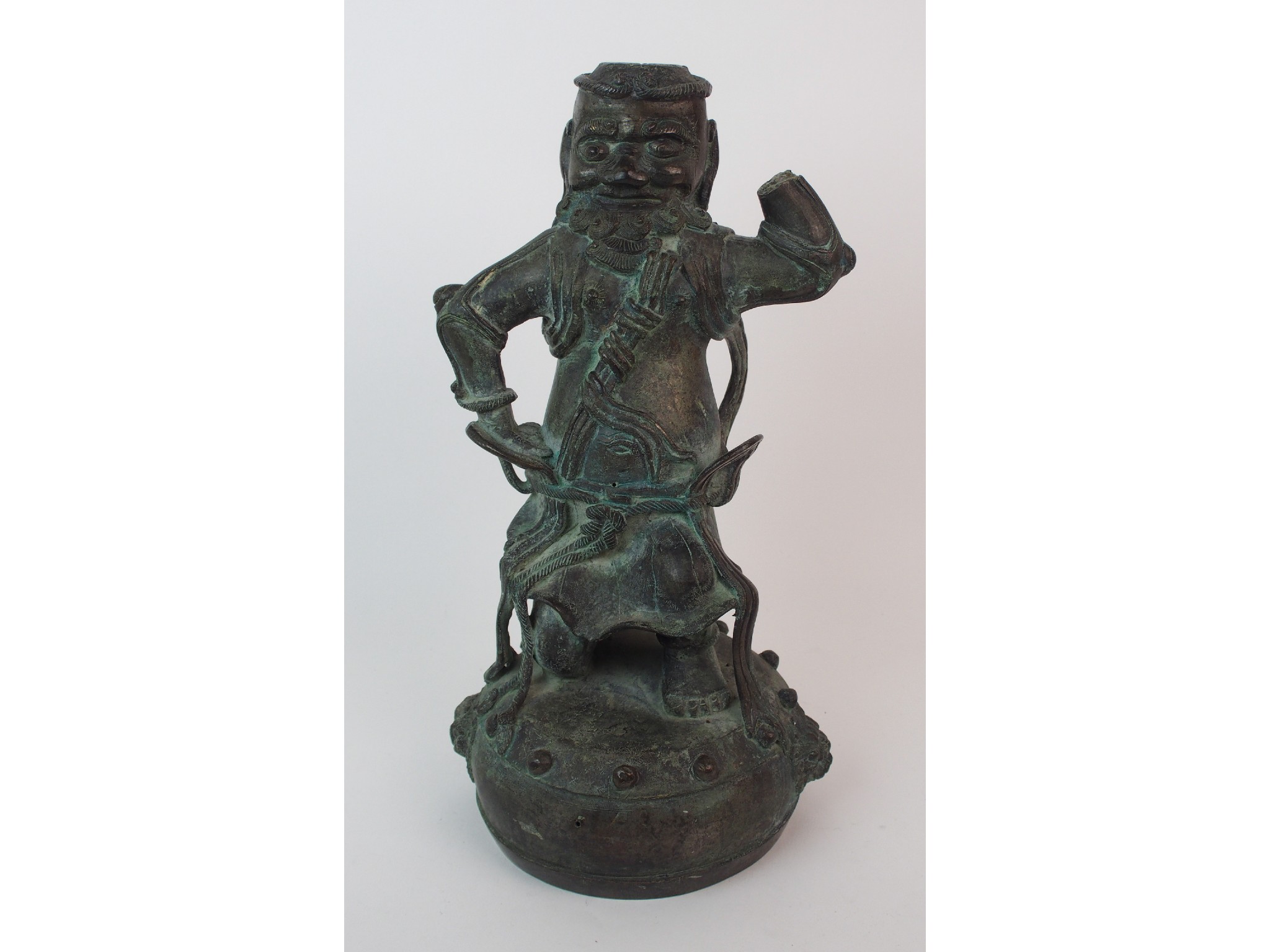 Appraisal: A Chinese bronze figure of a Guardian standing on a