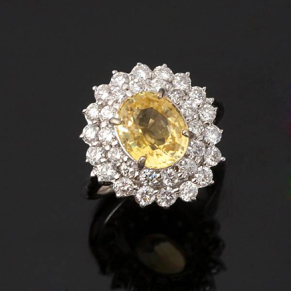 Appraisal: A golden sapphire and diamond ring centering an oval-shaped golden