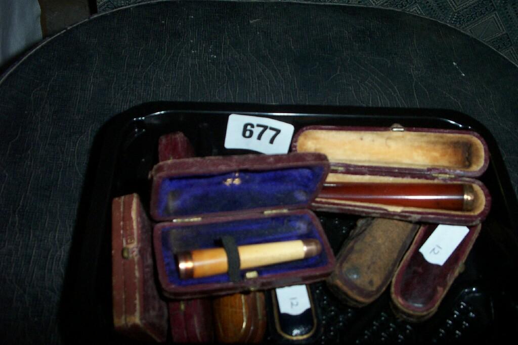 Appraisal: A collection of nine cased old cigarette holders in amber