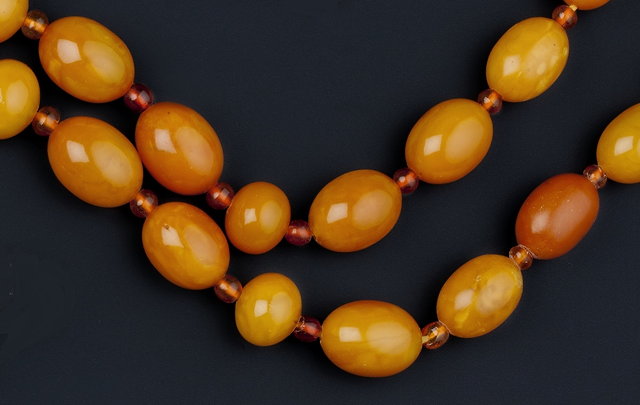 Appraisal: A GRADUATED AMBER BEAD NECKLACE AND AN AMBER PENDANT the